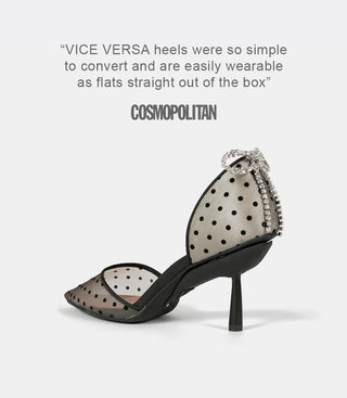High-heeled shoe with black polka dots and rhinestone bow detail, shown from a 3/4 back angle