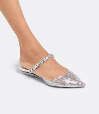 Model wearing the VICE VERSA Isadora Mule in clear crystal folded into a flat