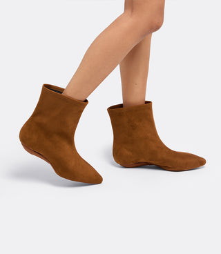 Model wearing the VICE VERSA Bowery Boot in walnut faux suede ankle boots, one in heel mode and one folded flat