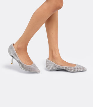 Model wearing the VICE VERSA Ella Pumps in silver crystal mesh, one in heel mode and one folded flat