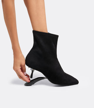Model folding the heel of the VICE VERSA Bowery Boot in black ankle boot to convert it to a flat