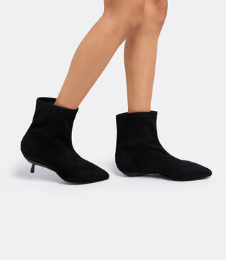 Model wearing the VICE VERSA Bowery Boot in black ankle boots, one in heel mode and one folded flat
