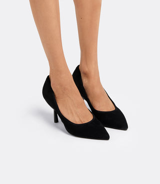 Model wearing the VICE VERSA Ella Pumps in black suede, one in heel mode and one folded flat