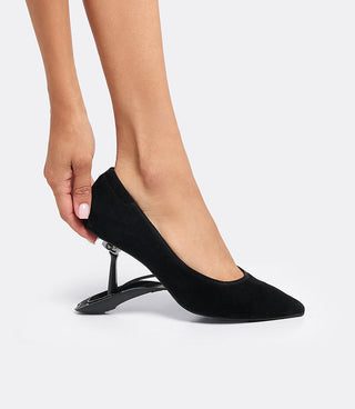 Model folding the heel of the VICE VERSA Ella Pump in black suede to convert it to a flat