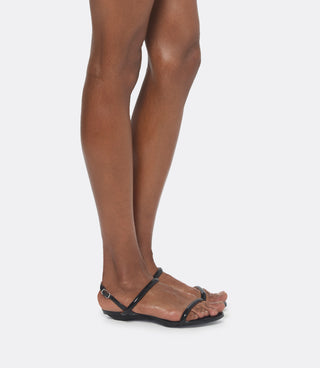 Model wearing black leather sandals as a flats.