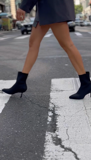 Person wearing black high-heeled boots on a city street