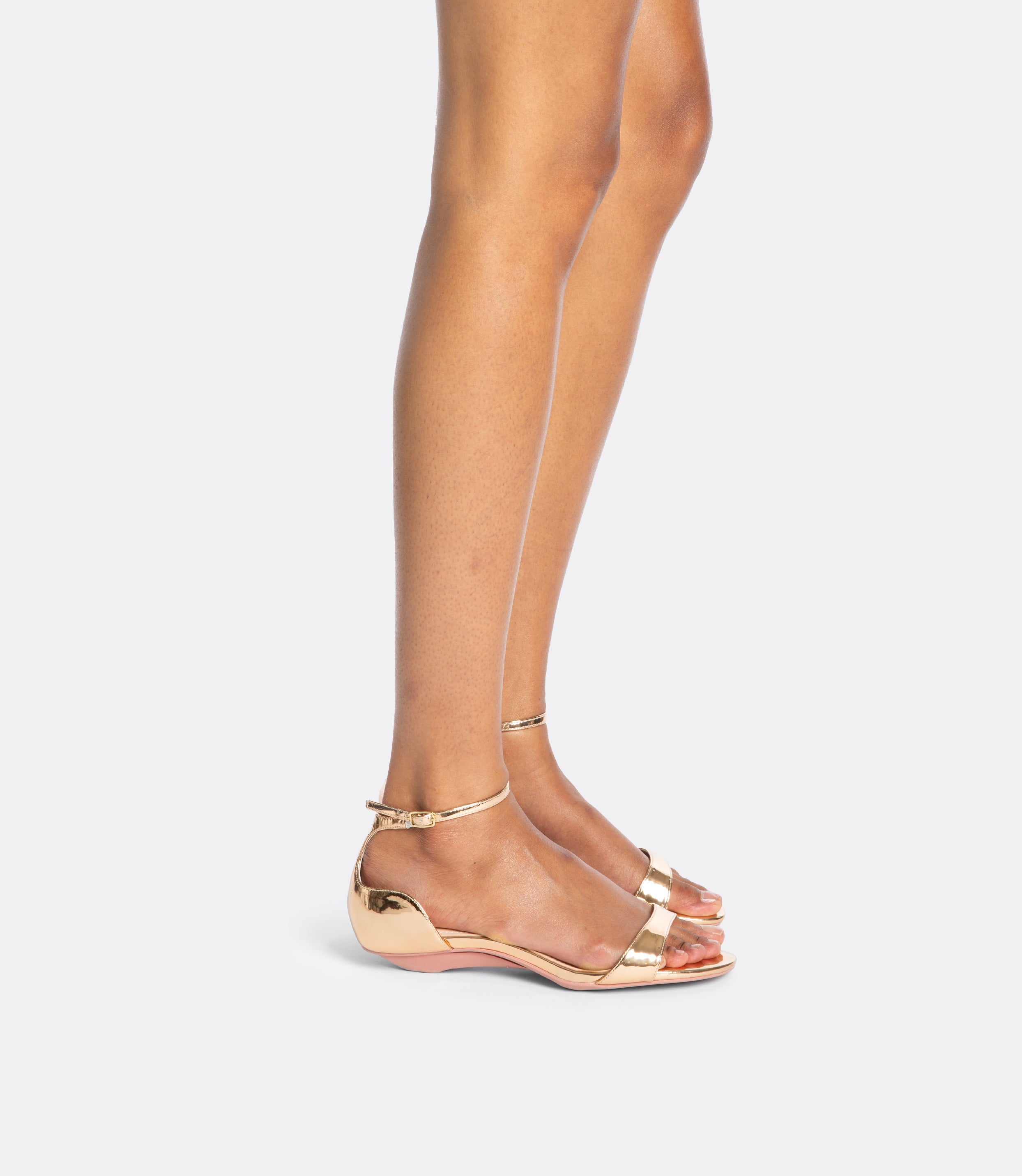 Model wearing the rose gold editor sandals as flats.