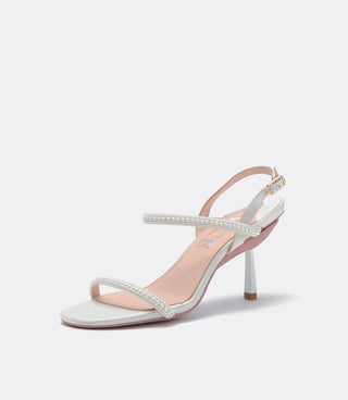 White high-heeled sandal with pearl strap on a light gray background