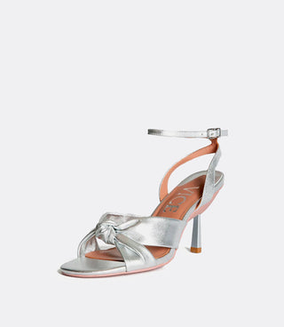 Silver sandal with knotted strap and ankle buckle, brand name VICE visible inside.