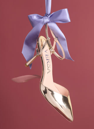 Gold high-heeled shoe ornament with a purple ribbon on a red background