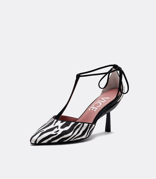 A single women's pointed-toe high heel shoe with a black and white zebra print upper, black T-strap and heel, and a pink insole with the brand name 'VICE' in white.