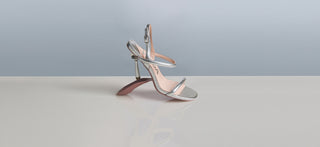 Silver high-heeled sandal on a light gray background