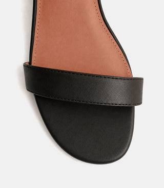 Black sandal with a tan insole on a white background